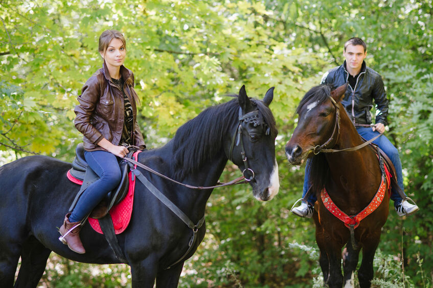 A couple on horses enjoying the benefits of horseback riding
