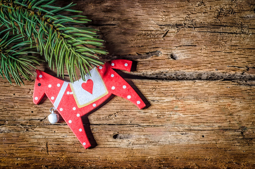 Christmas horse decoration, and pine branch on wood, with copy space
