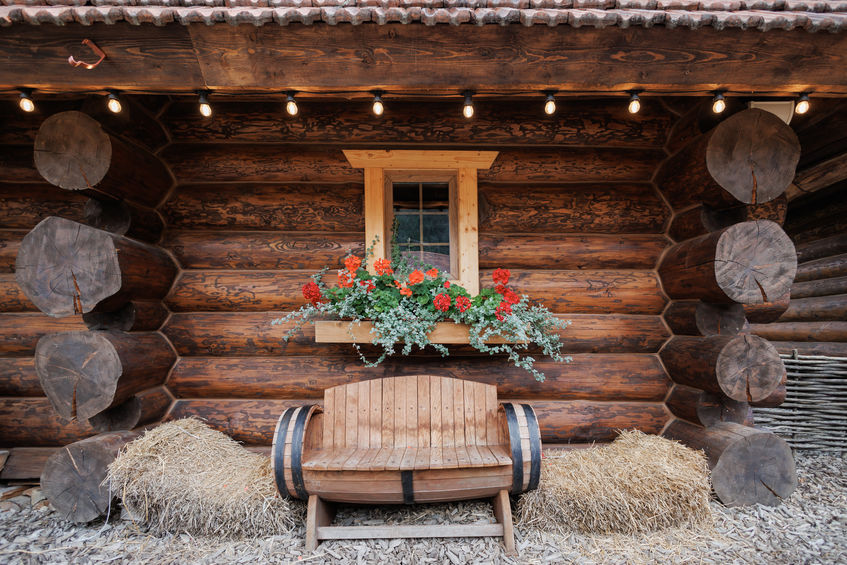 Rustic wooden bench in front of barn on a nice summer day with sun rising or setting